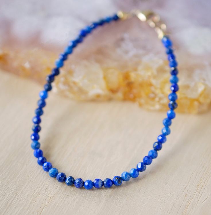 Handcrafted with love, this minimalist beauty is designed with natural faceted Lapis Lazuli gems. Lapis Lazuli is a metamorphic rock comprised of several minerals including: lazurite, sodalite, and calcite. It is believed to be a stone of truth that helps one gain self-awareness and encourages honesty in all things. It is also great for those working on their own self-acceptance. Our bracelet is handmade in your choice of sterling silver or 14k gold filled. So go ahead, rock on! GEMSTONE: Natura Everyday Rondelle Jewelry With Faceted Beads, Lapis Lazuli Jewelry With Faceted Beads, Everyday Faceted Rondelle Bracelets, Healing Lapis Lazuli Jewelry With Faceted Beads, Minimalist Faceted Rondelle Beaded Bracelets, Lapis Lazuli Faceted Beads Jewelry For Gift, Lapis Lazuli Jewelry With Faceted Beads For Gift, Faceted Lapis Lazuli Beads Jewelry For Gift, Everyday Lapis Lazuli Jewelry With Gemstone Beads