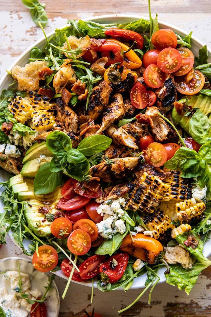 a salad with grilled chicken, tomatoes and lettuce