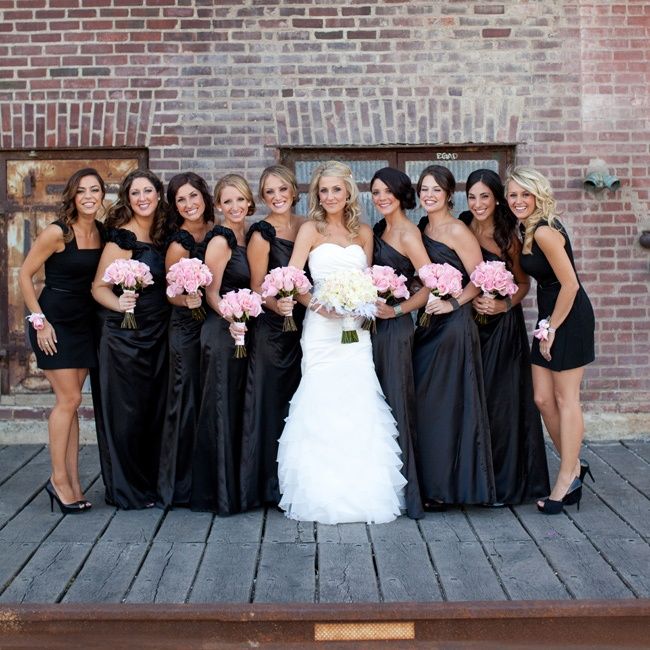 a group of women standing next to each other in front of a brick wall and door