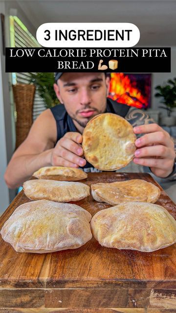 the man is making bread on the table with his hands and looking at it in front of him