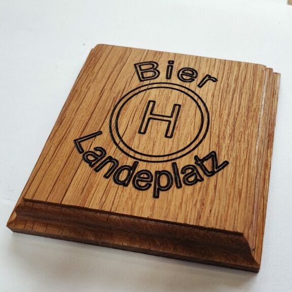 a wooden coaster with the word'blier landeplat'engraved on it