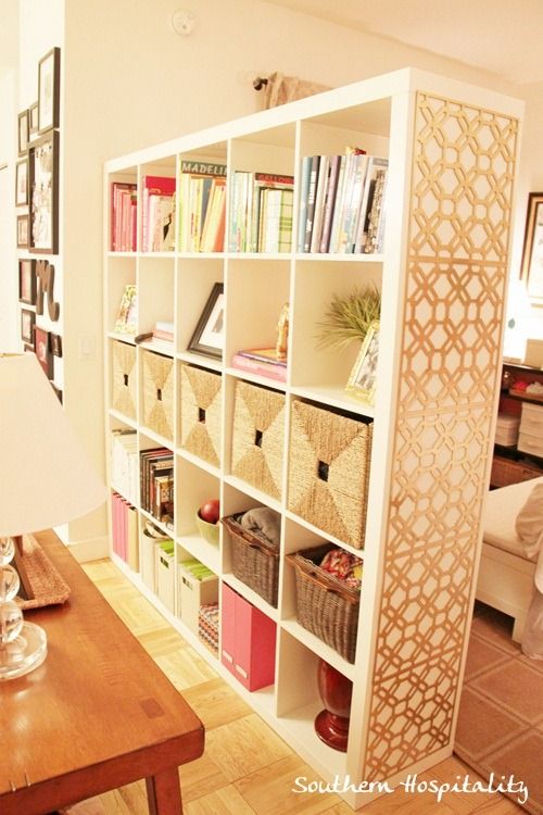 a living room filled with furniture and bookshelves next to a wall covered in pictures