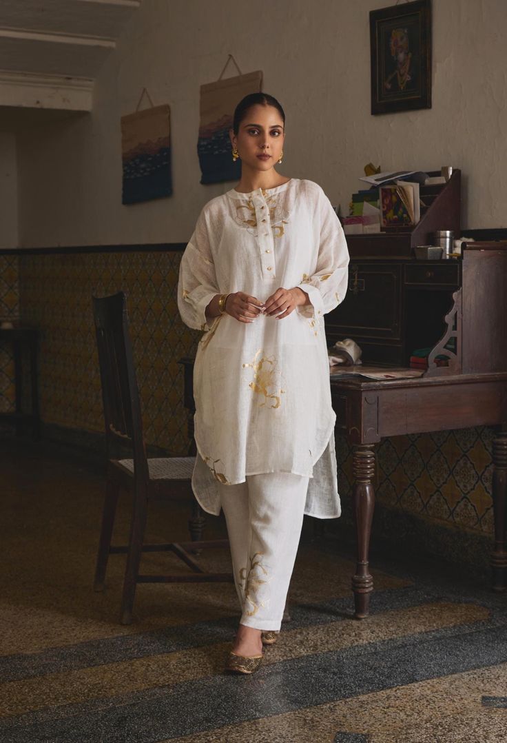 Pristine, elegant, and chic, the Manmohini Co-ord Set is perfect for the woman who swears by understated luxury. As gold florals peek out this gauze linen set and dainty buttons add a delicate regal touch, you can be assured of maximum comfort without any compromises on the style. MODEL DETAILS Model Name-Raghvi Sehgal  Bust- 32.5  Arms- 10.9  Hips-37  Height - 5.6 Fabric: 100% Gauze Linen Characteristics of Linen : Hygroscopic All Natural UV Protection Kind On Skin Naturally Breathable Strong Improves With Age Handmade With Love In India By Yell Retail India. Elegant Beige Lawn Suit For Summer, Elegant Straight Kurta Pant Set For Spring, Linen Sets With Chikankari Embroidery For Summer, Elegant Cotton Sets With Chikankari Embroidery, Elegant Cotton Sets For Festive Occasions, Linen Straight Kurta Set For Summer, Summer Linen Straight Kurta Set, Summer Linen Sets With Chikankari Embroidery, Elegant Linen Kurta For Spring