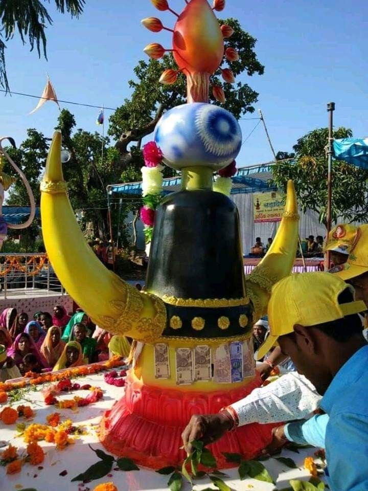 two men in yellow hats are standing next to a float