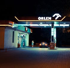 an open gas station at night with the lights on