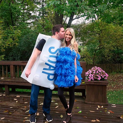 a man and woman dressed up in costumes standing on a deck with a sign that says save the date