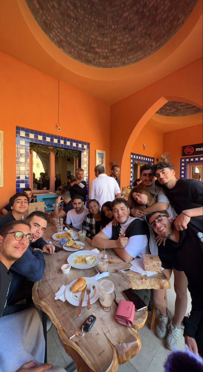 a group of people sitting around a wooden table