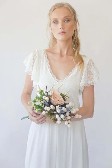 a woman in a white dress holding a bouquet of flowers