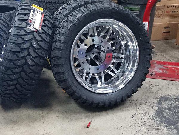 two large tires are stacked on top of each other in front of a red truck