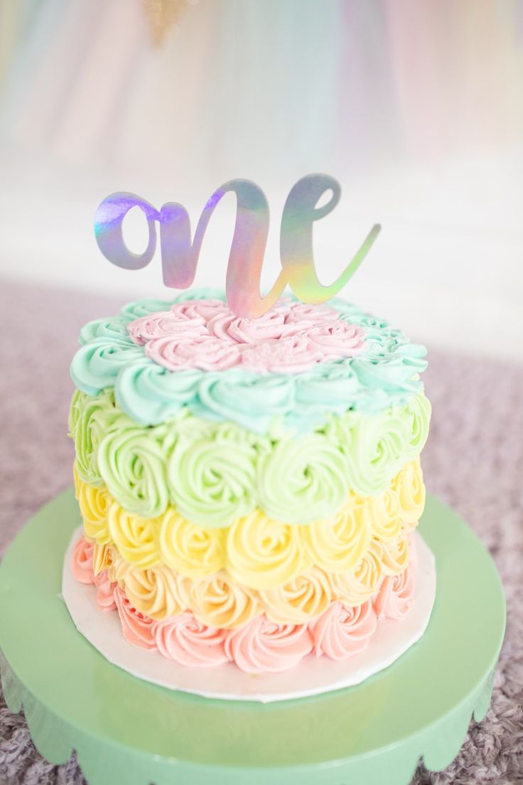 a multicolored cake sitting on top of a green plate