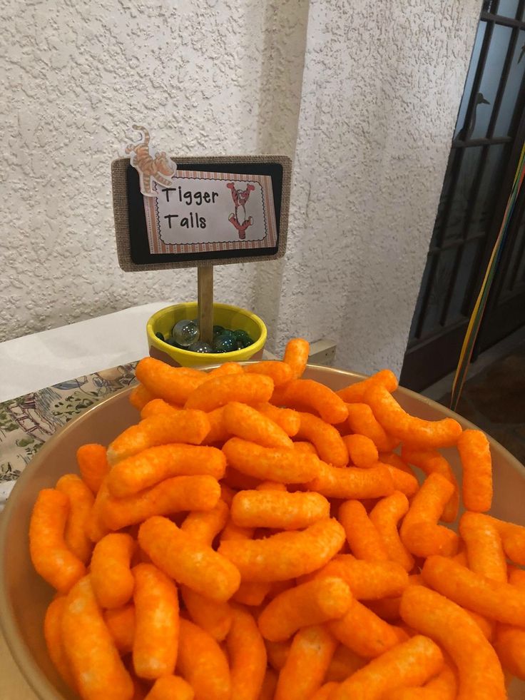 a bowl full of carrots with a sign on top that says tiger tails in front of it