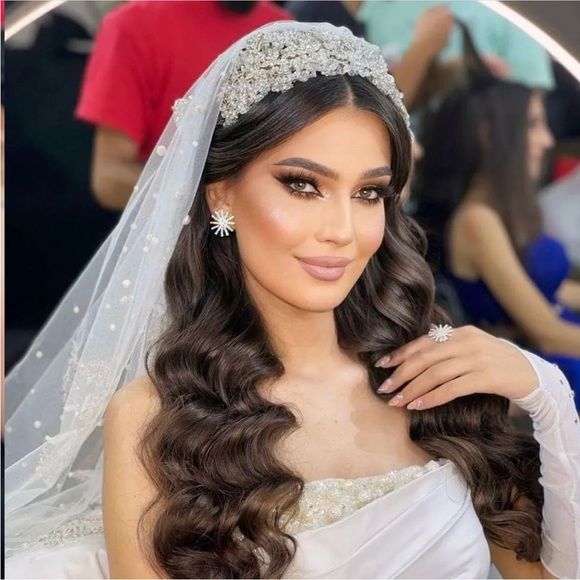 a woman in a wedding dress with long hair wearing a veil and tiara on her head