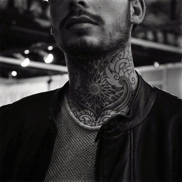 black and white photograph of a man with tattoos on his neck