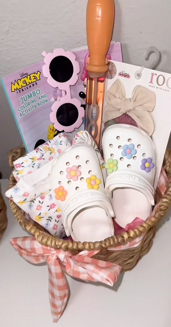 a basket filled with white shoes and accessories sitting on top of a table next to a book