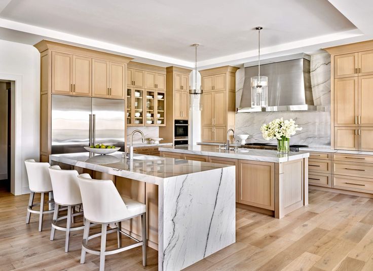 a large kitchen with marble counter tops and wooden floors