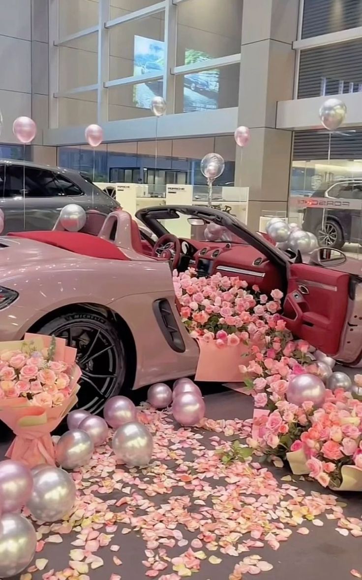 the car is decorated with pink flowers and balloons