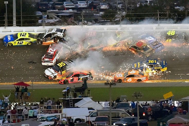 two cars collide on top of each other in a race