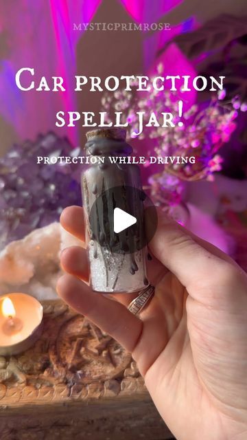 a person holding a small bottle in their hand with the words car protection spell jar