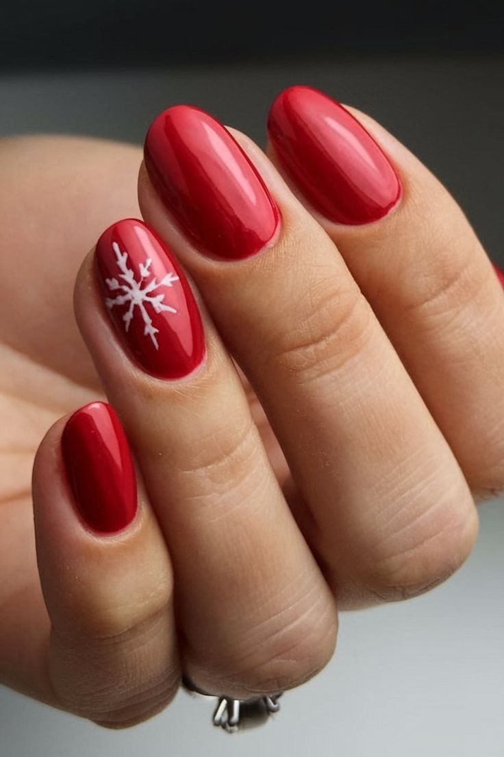 A simple yet elegant red nail design with a white snowflake on the ring finger, perfect for the holiday season. The glossy red finish adds a vibrant touch, while the snowflake art brings in the winter spirit. Red Nails With Snowflake, Nails With Snowflake Design, Red Nail Design, Christmas Snowflakes Nails, Snowflake Art, Red And White Nails, Ring Finger Nails, Red Christmas Nails, Red Acrylic Nails