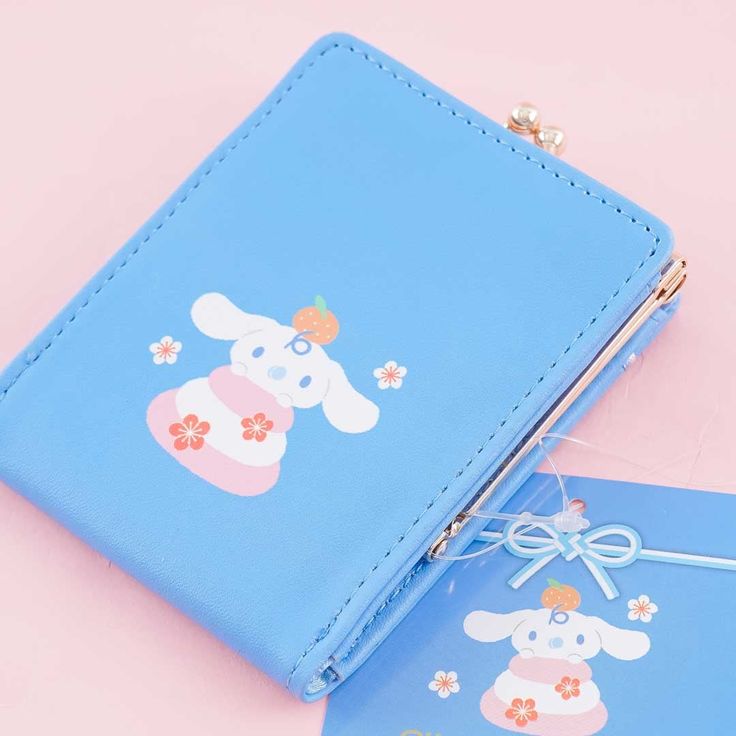 Use this kawaii clutch purse to keep your loose change. "Gamaguchi" is a traditional pouch in Japan and is considered a lucky purse! It features a ribbon and is printed with illustrations of Cinnamoroll and Milk. It has a golden metal clasp so you can easily secure your coins. A super cute Japanese pouch featuring the Cinnamoroll and Milk Features an inner pocket, a ribbon, and a golden metal clasp Original licensed product from Sanrio Japan Kawaii Wallet With Card Slots, Kawaii Rectangular Wallets With Card Slots, Kawaii Coin Purse With Card Slots For Gift, Cute Blue Rectangular Wallet, Cute Rectangular Coin Purse For School, Cute Blue Rectangular Coin Purse, Kawaii Rectangular Coin Purse Gift, Cute Blue Wallets For Gifts, Cute Blue Wallets For Gift