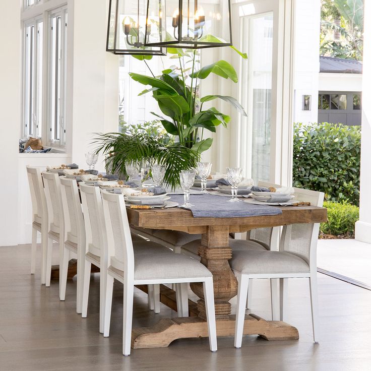 a dining room table with chairs and a potted plant on top of the table