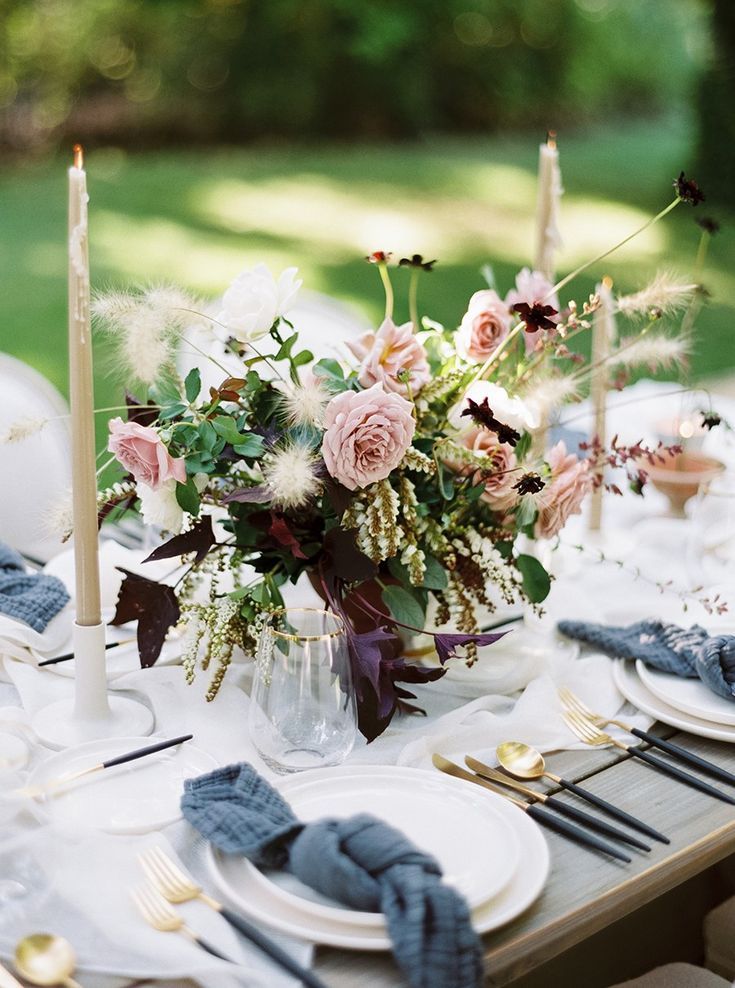 the table is set with flowers and candles