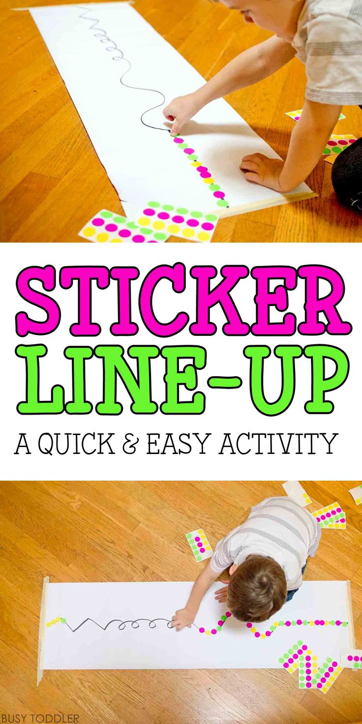 two children are playing with sticker line - up on the floor, and one child is