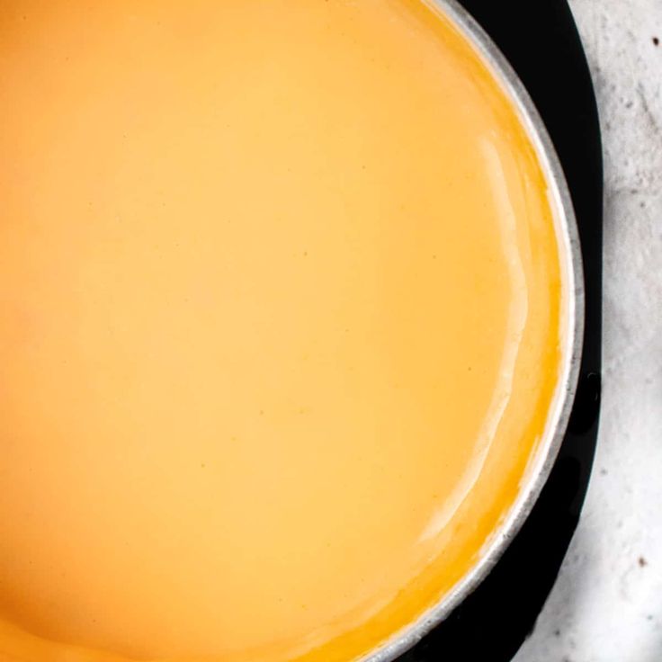 a pan filled with yellow liquid sitting on top of a stove