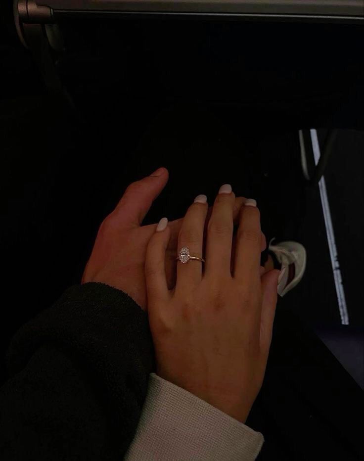 a woman's hand with a diamond ring on her finger