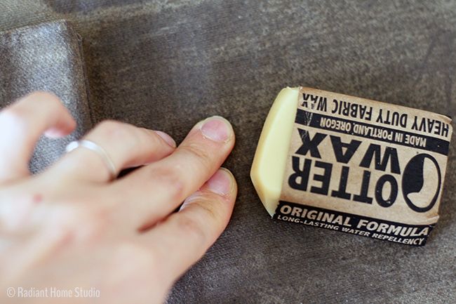 a person holding a piece of cheese next to it's own hand on a couch