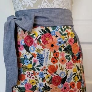 a woman's skirt with flowers on it and a gray tie around the waist