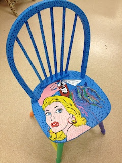 a blue plastic chair with a woman's face painted on the back of it