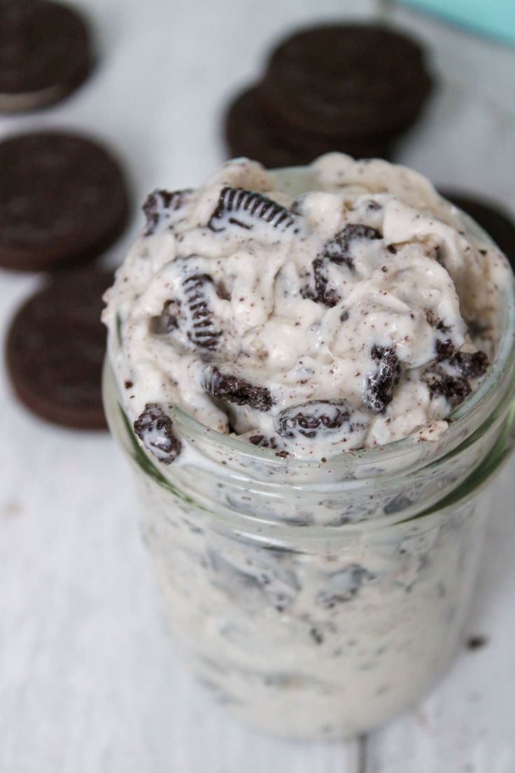 oreo cookies and cream in a mason jar on a white table with cookie cookies