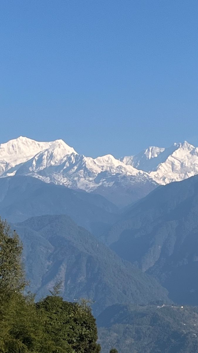 the mountains are covered in snow on a sunny day