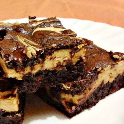 a white plate topped with brownies covered in chocolate and oreo pieces on top of each other