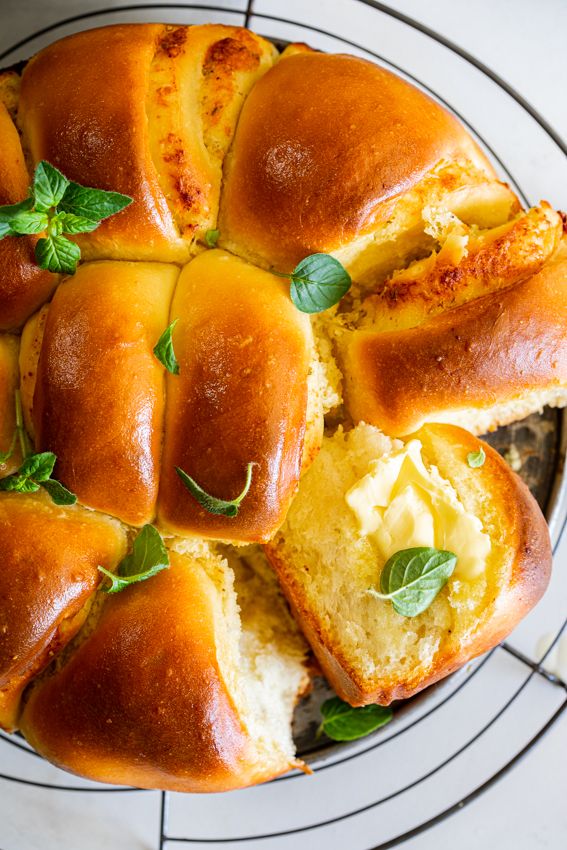 bread with cheese and herbs on top sitting on a plate