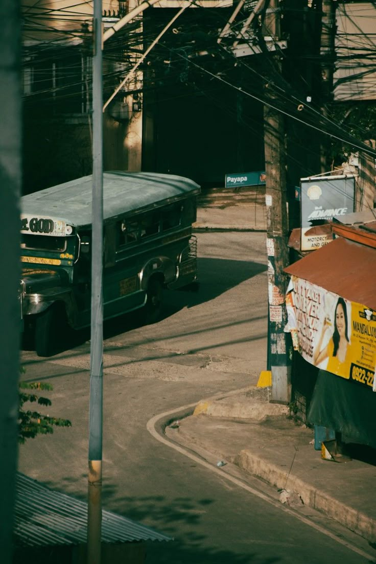 two buses parked on the side of a road next to a street sign and telephone pole