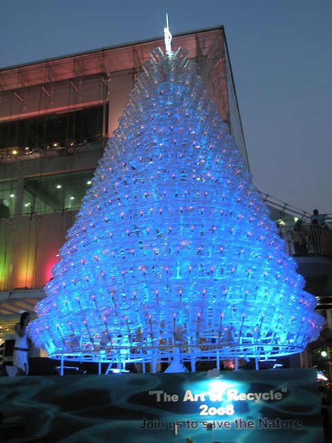 a large blue christmas tree in front of a building