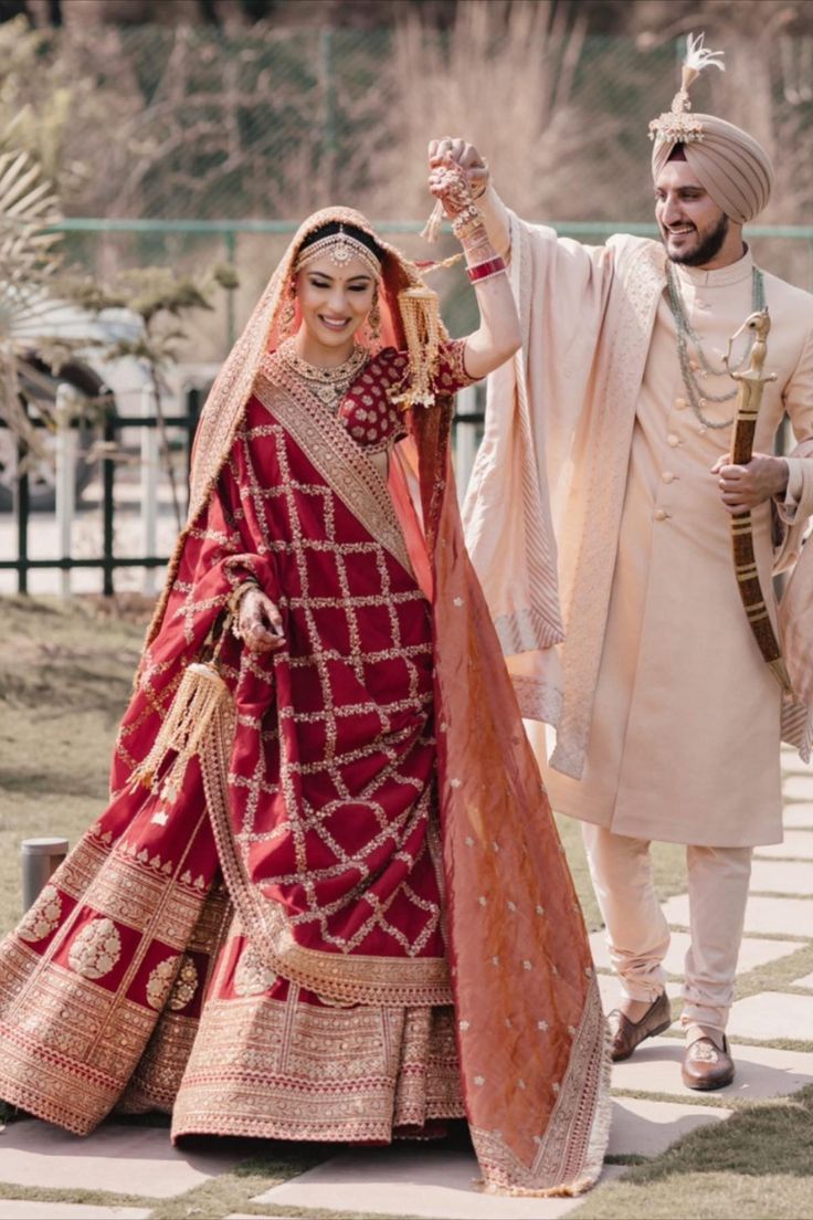 Sikh bride in a deep red Sabyasachi lehenga with the groom in an Ivory outfit भारतीय दुल्हन संबंधी, Best Indian Wedding Dresses, Indian Wedding Lehenga, Groom Dress Men, Indian Groom Wear, Wedding Dresses Men Indian, Pengantin India, Latest Bridal Lehenga, Couple Wedding Dress