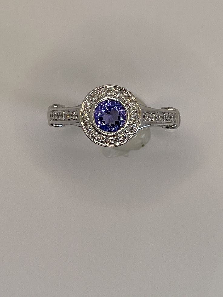 0.54ct Tanzanite 0.82ctw Diamonds 14k White Gold Classic Diamond Ring With Round Gemstone, Formal Tanzanite Rings With Halo Design, Dazzling Formal Halo Ring With Round Stone, Dazzling Tanzanite Rings, Formal Diamond Ring With Halo Design And Round Stone, Elegant Tanzanite Diamond Ring, Elegant Tanzanite Diamond Ring With Halo Design, Classic 14k White Gold Diamond Ring With Gemstone, Classic 14k White Gold Diamond Ring