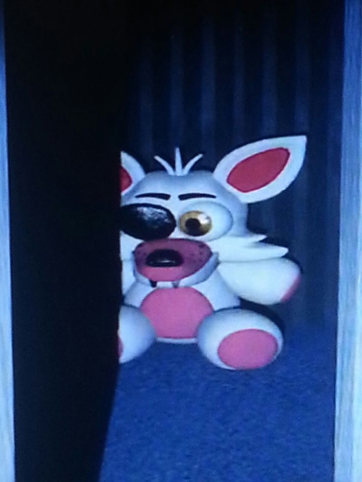 a stuffed animal sitting on the floor in front of a door with its mouth open