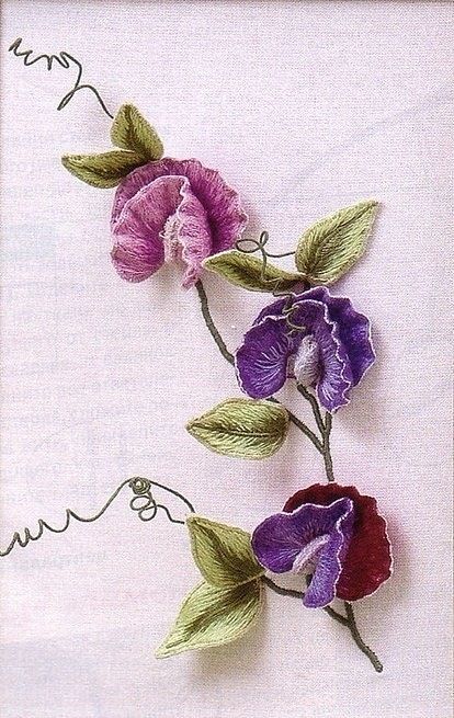 two purple and red flowers with green leaves on the stems are embroidered onto a white cloth