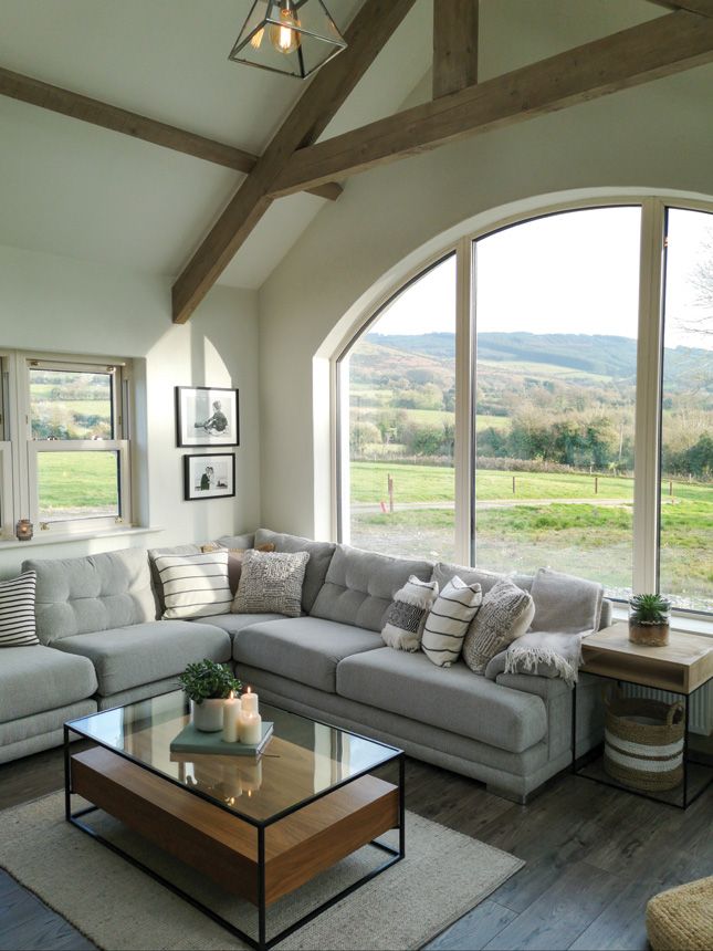 a living room filled with furniture and large windows