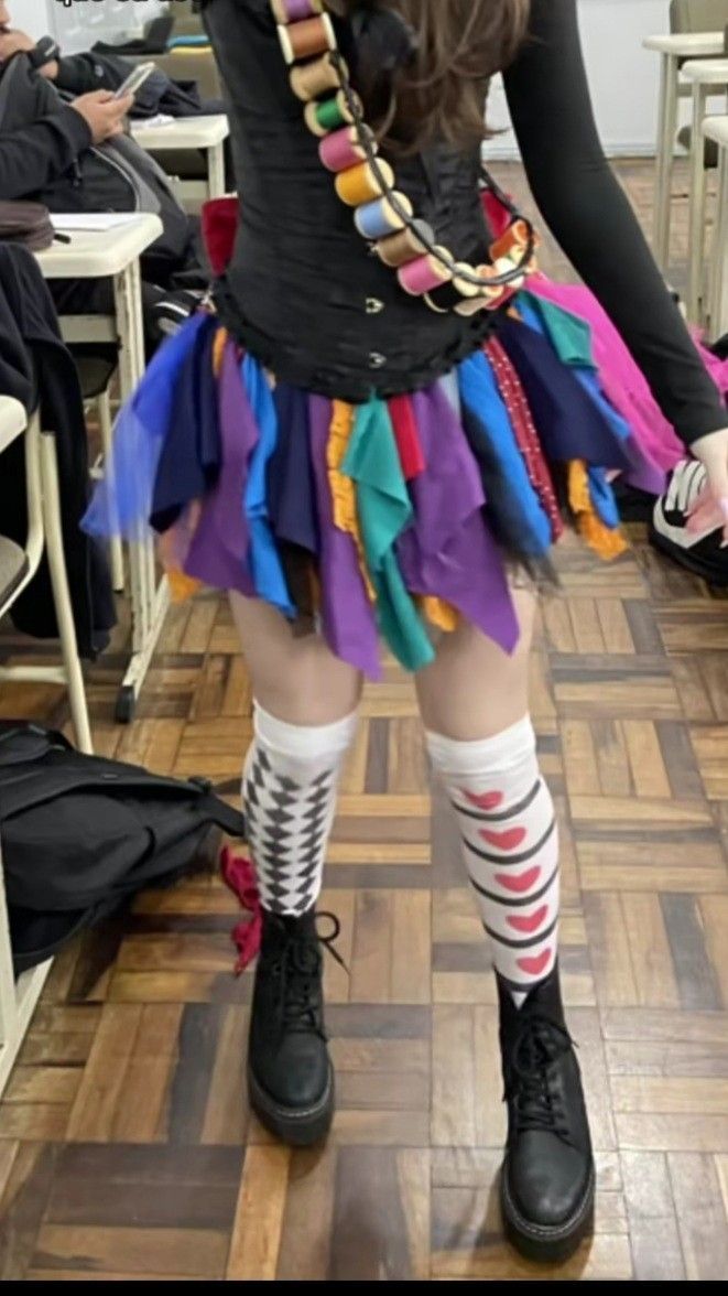 a woman dressed up as a clown posing for the camera