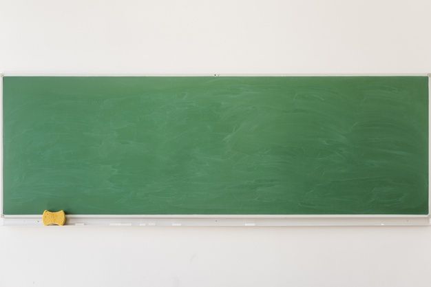 a green chalk board mounted to the side of a wall next to a yellow piece of paper