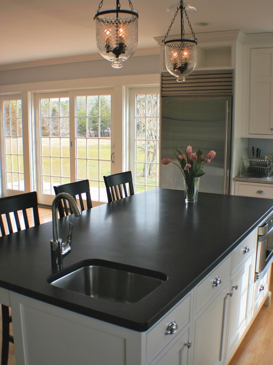 a large kitchen with an island in the middle and lots of windows on both sides