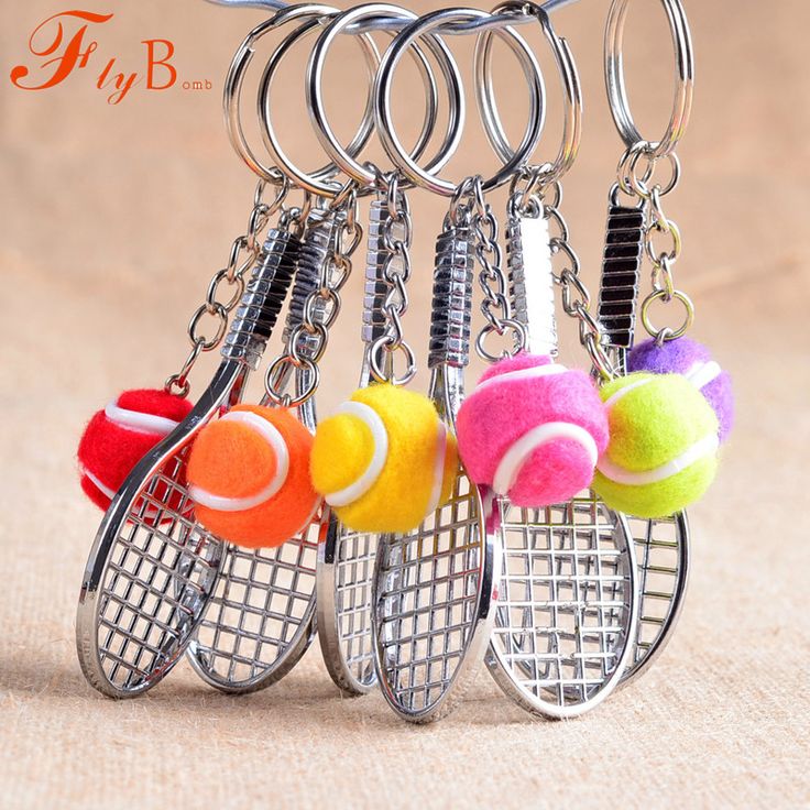 four tennis balls and rackets are hanging from the keychain that is attached to each other