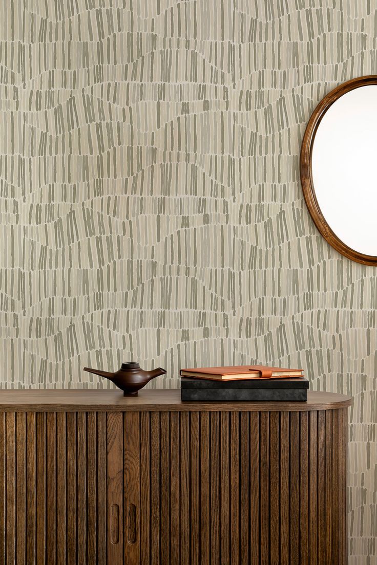 a wooden cabinet with a mirror above it and a bowl on top of it in front of a wall