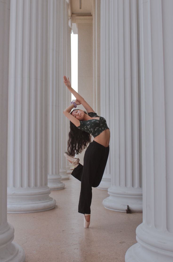 a woman is doing a handstand in front of some white pillars and columns