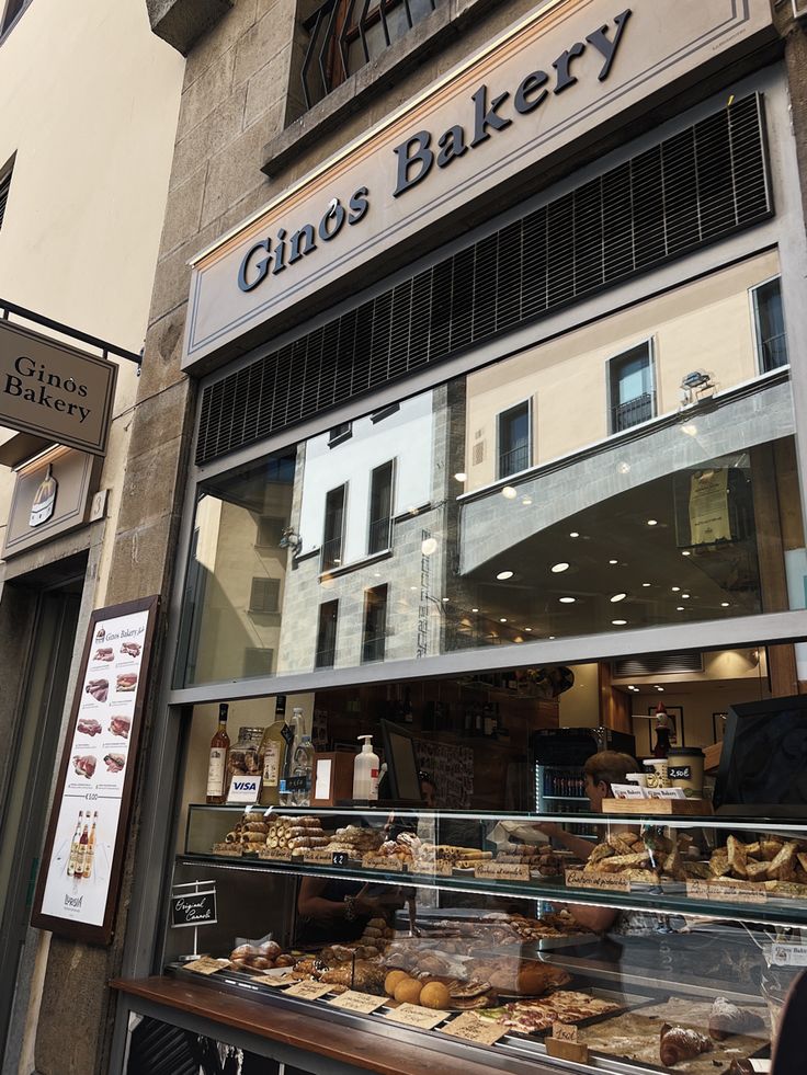 an outside view of a bakery with lots of pastries